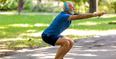 A middle-aged man doing squats for knee strengthening.