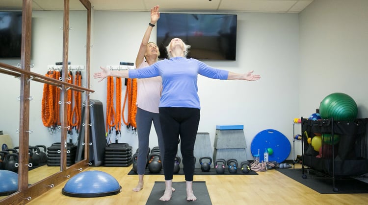 A physical therapist working with a patient on balance