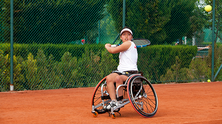Person in a wheelchair playing tennis
