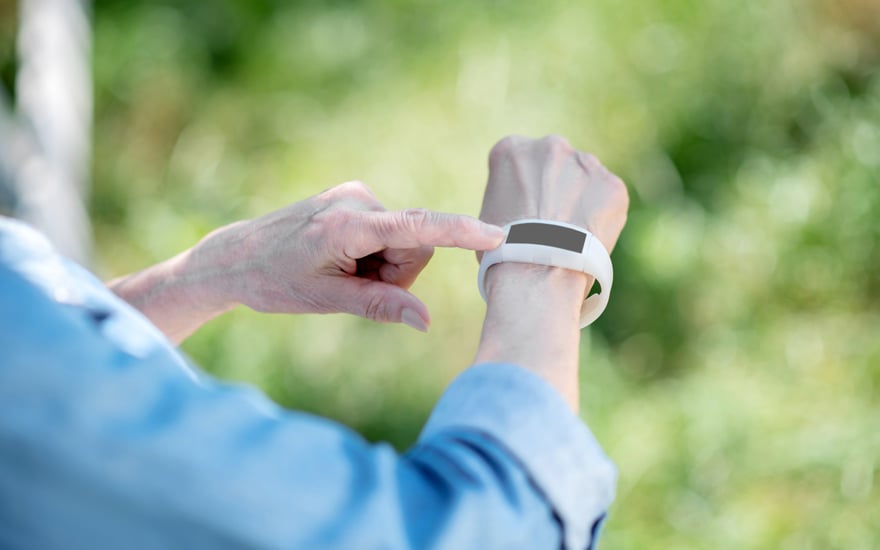 An older adult using a wearable to track steps for physical activity.